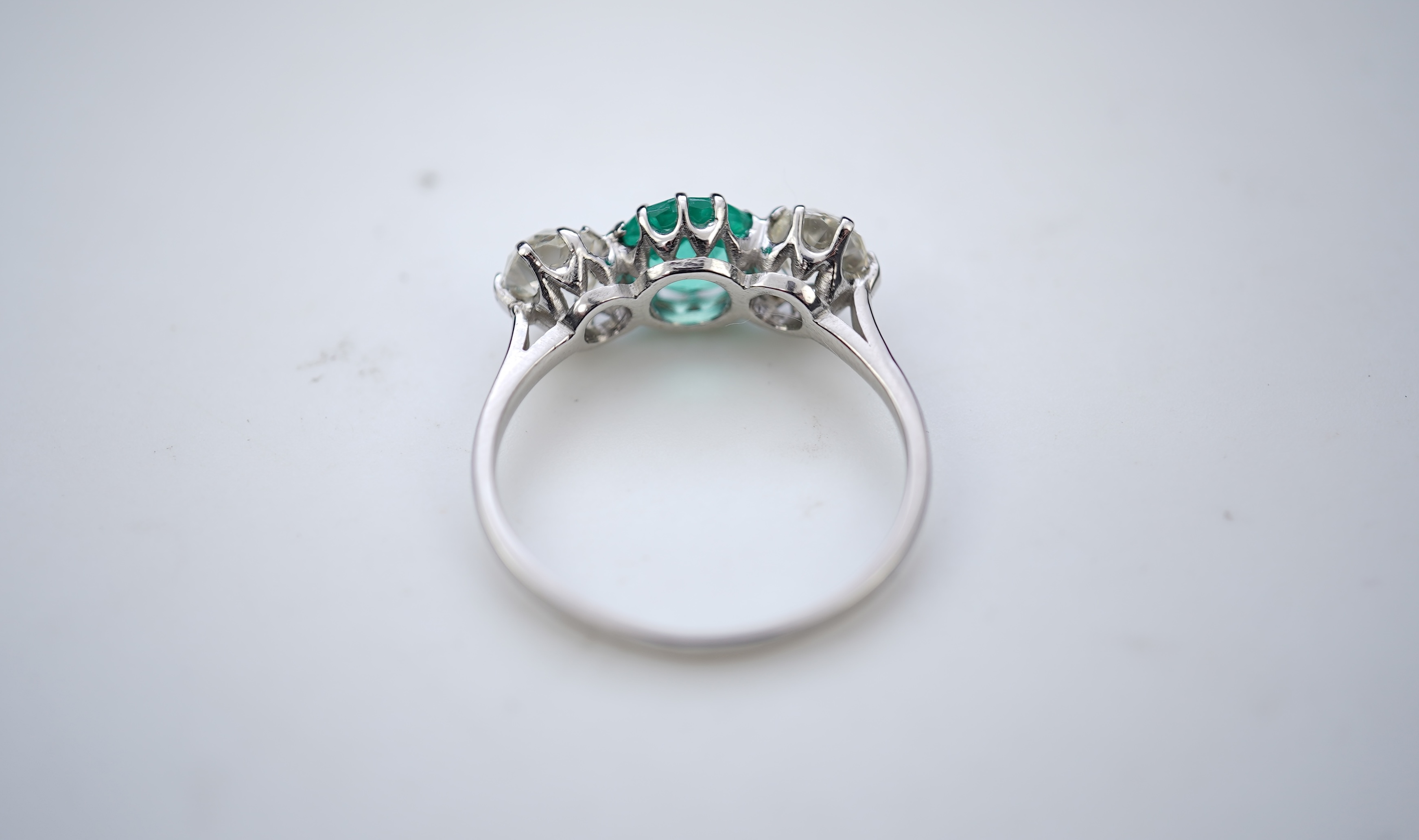 An attractive emerald and diamond three-stone ring, early 20th century